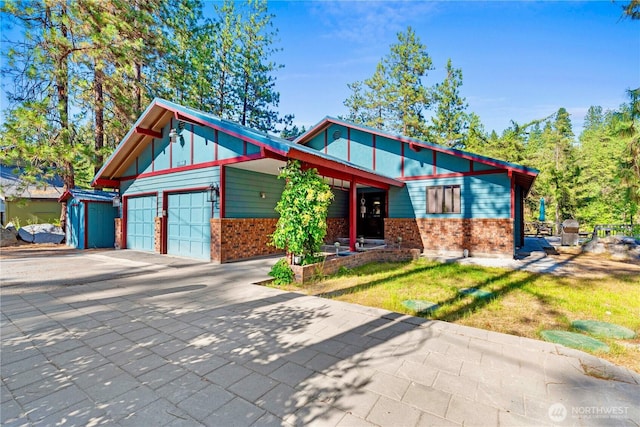 11358 River Bend Dr, Leavenworth, WA 98826 - view of front of house with brick siding, a garage, concrete driveway, and a front lawn