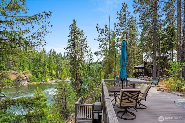 11358 River Bend Dr, Leavenworth, WA 98826 - deck featuring outdoor dining space, a water view, and a wooded view