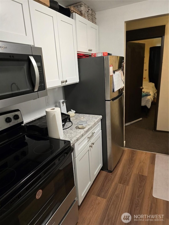 102 Garden Hill Rd, Elma, WA 98541 - kitchen featuring appliances with stainless steel finishes, dark wood-style flooring, white cabinetry, and light stone countertops