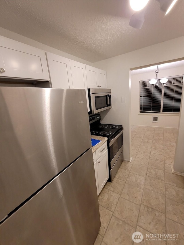 102 Garden Hill Rd, Elma, WA 98541 - kitchen featuring stainless steel appliances, white cabinetry, a chandelier, light countertops, and a textured ceiling