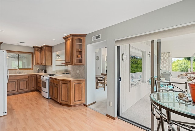 225 NE 19th St Unit 24, East Wenatchee, WA 98802 - kitchen featuring white appliances, brown cabinetry, light countertops, and light wood-type flooring