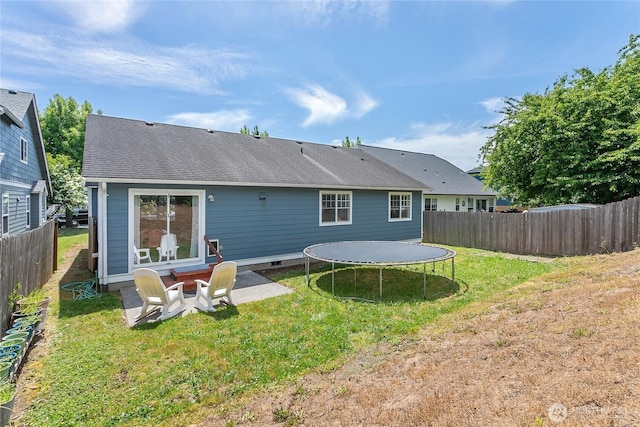 1339 Spruce St, Lynden, WA 98264 - rear view of house with a trampoline, a fenced backyard, roof with shingles, and a patio area
