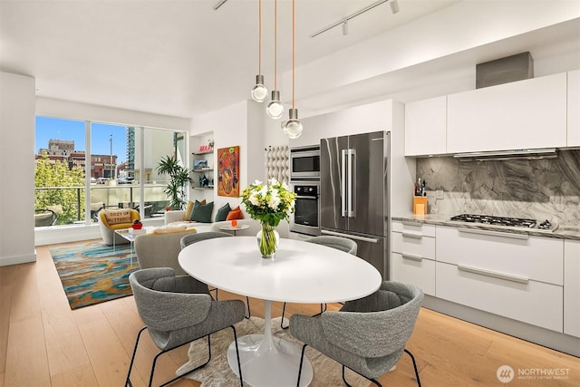 1920 4th Ave Unit 604, Seattle, WA 98101 - kitchen with stainless steel appliances, modern cabinets, light wood-type flooring, and white cabinetry