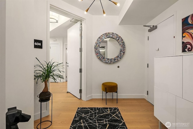 1920 4th Ave Unit 604, Seattle, WA 98101 - corridor with light wood finished floors and a chandelier