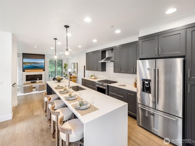 18517 96th Dr NE Unit A, Bothell, WA 98011 - kitchen with high quality appliances, wall chimney range hood, a kitchen bar, light countertops, and backsplash