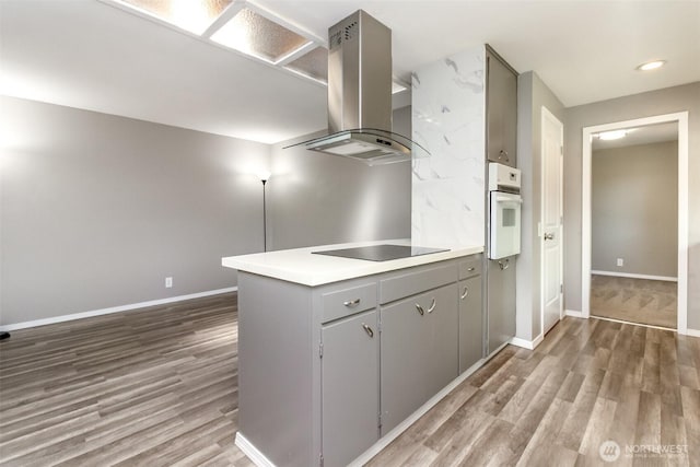 32206 27th Ave SW, Federal Way, WA 98032 - kitchen with island range hood, white oven, black electric stovetop, gray cabinetry, and wood finished floors