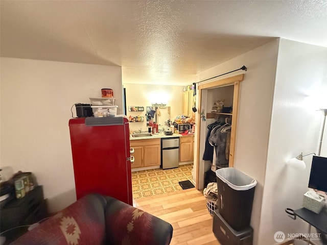 408 Main St, Conconully, WA 98844 - kitchen with refrigerator, a textured ceiling, light wood-style floors, stainless steel microwave, and light countertops