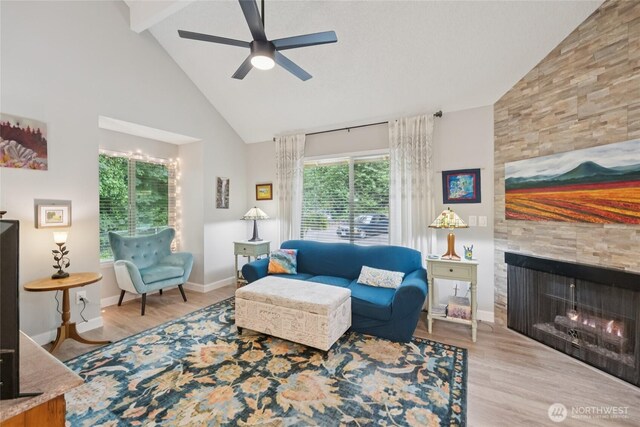 12912 62nd Ave NW Unit B5, Gig Harbor, WA 98332 - living area with high vaulted ceiling, wood finished floors, a ceiling fan, a tiled fireplace, and beamed ceiling