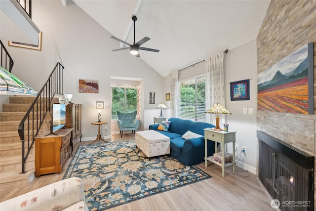 12912 62nd Ave NW Unit B5, Gig Harbor, WA 98332 - living area featuring a ceiling fan, stairway, a fireplace, light wood finished floors, and high vaulted ceiling