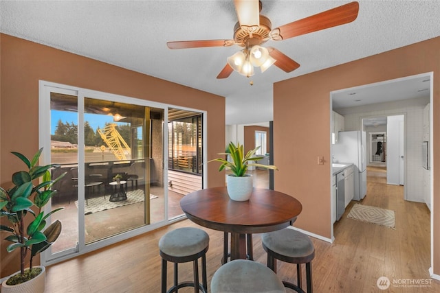 5915 Highway Pl Unit 403, Everett, WA 98203 - dining room featuring light wood finished floors, ceiling fan, and a textured ceiling