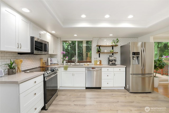 10435 NE 135th Pl, Kirkland, WA 98034 - kitchen with appliances with stainless steel finishes, ornamental molding, a tray ceiling, decorative backsplash, and white cabinets