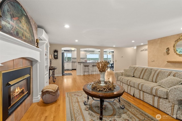 6600 Klein St NW, Olympia, WA 98502 - living area featuring a tile fireplace, recessed lighting, light wood-style floors, and a wall unit AC