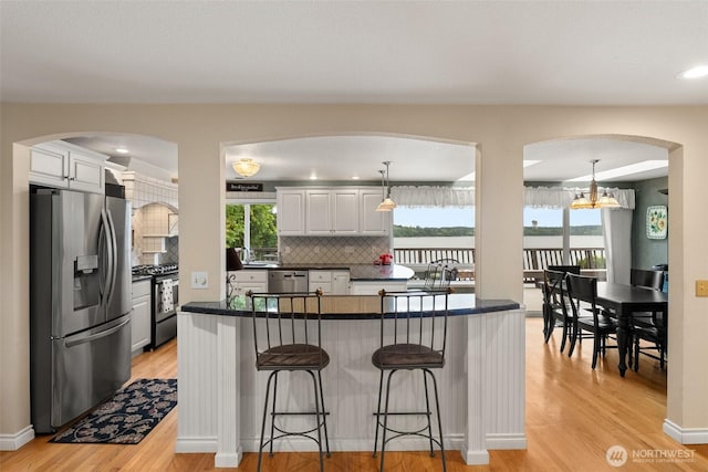 6600 Klein St NW, Olympia, WA 98502 - kitchen with appliances with stainless steel finishes, arched walkways, dark countertops, and decorative backsplash