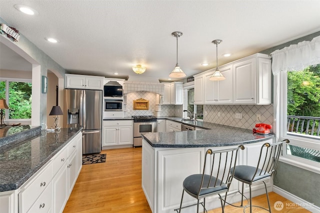 6600 Klein St NW, Olympia, WA 98502 - kitchen featuring stainless steel appliances, a peninsula, white cabinets, backsplash, and recessed lighting