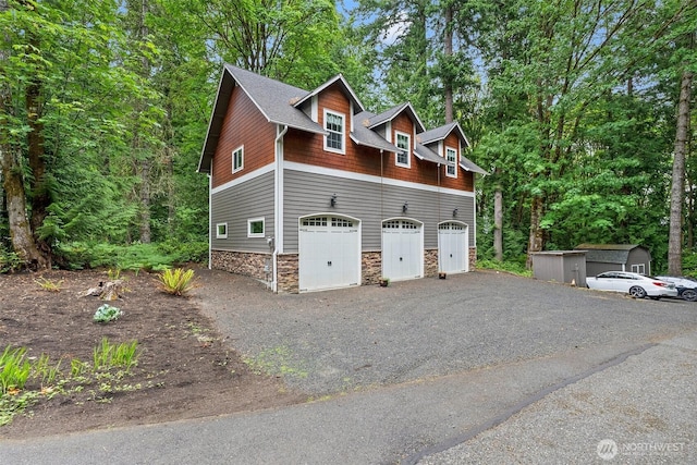 6600 Klein St NW, Olympia, WA 98502 - view of side of home with stone siding, a garage, and driveway
