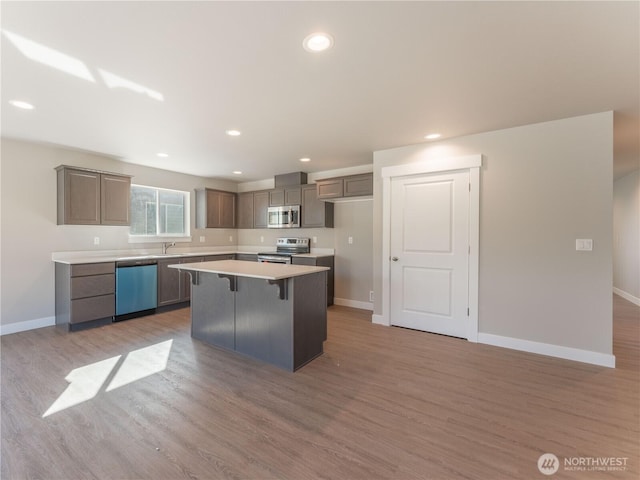 22 Salmon Dr, Wenatchee, WA 98801 - kitchen featuring appliances with stainless steel finishes, a center island, light wood-style flooring, light countertops, and a kitchen breakfast bar