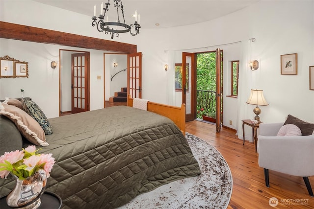 24917 Dockton Rd SW, Vashon, WA 98070 - bedroom with access to exterior, a chandelier, and wood finished floors