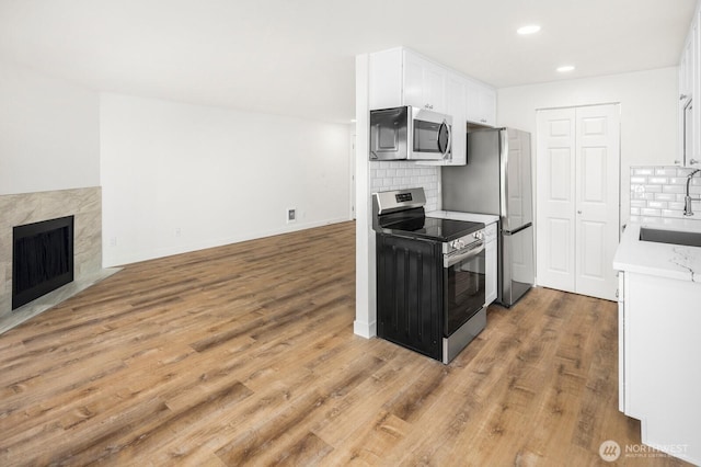 2020 Grant Ave S Unit B103, Renton, WA 98055 - kitchen featuring appliances with stainless steel finishes, a sink, backsplash, white cabinetry, and open floor plan