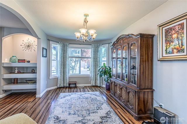 17716 25th Ave E, Tacoma, WA 98445 - dining room featuring a chandelier, wood finished floors, and arched walkways