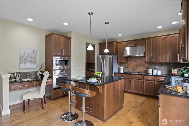 13020 112th Ave NE, Kirkland, WA 98034 - kitchen with under cabinet range hood, stainless steel appliances, light wood-type flooring, decorative backsplash, and recessed lighting