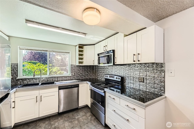 921 130th St SW Unit E102, Everett, WA 98204 - kitchen featuring appliances with stainless steel finishes, white cabinetry, tasteful backsplash, open shelves, and a textured ceiling