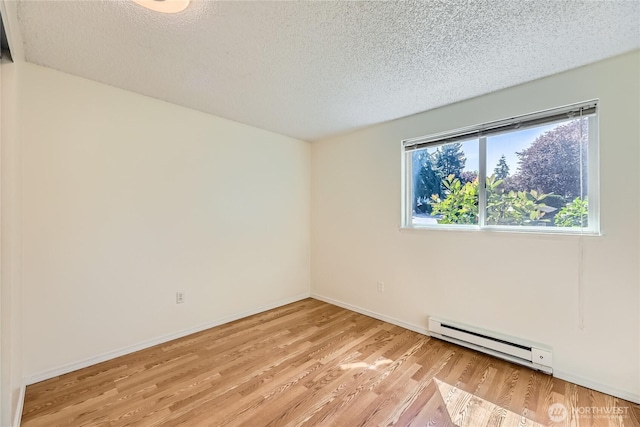 921 130th St SW Unit E102, Everett, WA 98204 - spare room with a baseboard heating unit, a textured ceiling, and wood finished floors