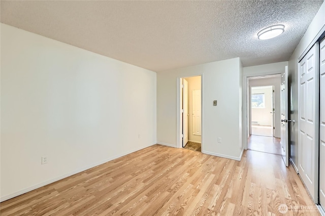 921 130th St SW Unit E102, Everett, WA 98204 - unfurnished bedroom featuring light wood finished floors and a textured ceiling