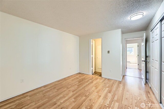 921 130th St SW Unit E102, Everett, WA 98204 - unfurnished bedroom featuring light wood finished floors and a textured ceiling