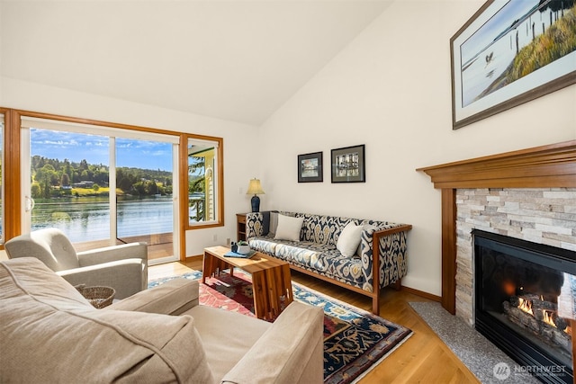 115 Quarry Rd, Port Ludlow, WA 98365 - living room with wood finished floors, a stone fireplace, a water view, and high vaulted ceiling