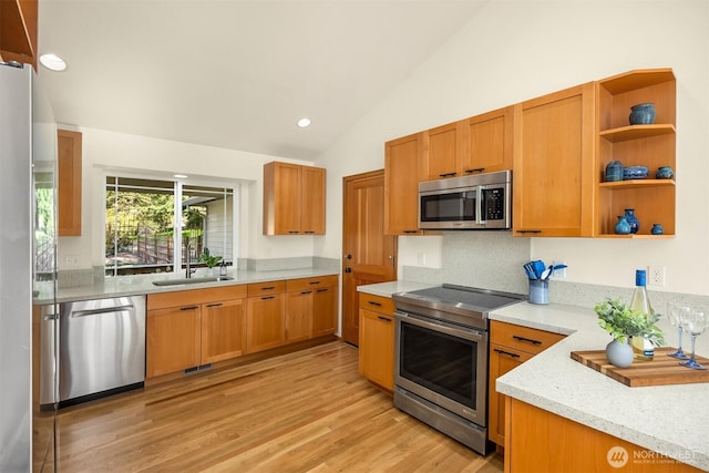 115 Quarry Rd, Port Ludlow, WA 98365 - kitchen featuring appliances with stainless steel finishes, lofted ceiling, light wood-type flooring, light stone counters, and tasteful backsplash
