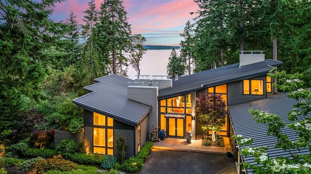 182 Island Blvd, Fox Island, WA 98333 - rear view of property with a chimney, a standing seam roof, and a metal roof