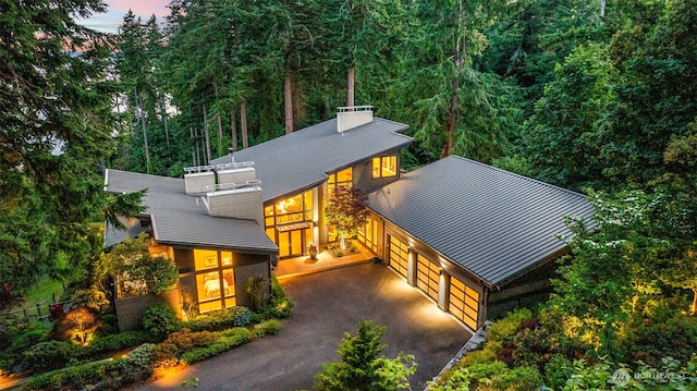 182 Island Blvd, Fox Island, WA 98333 - view of front of home featuring a standing seam roof, driveway, a balcony, a chimney, and a metal roof