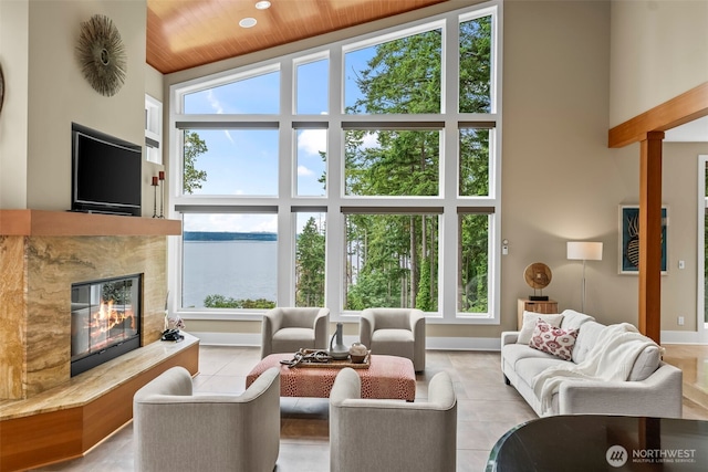 182 Island Blvd, Fox Island, WA 98333 - living room with a towering ceiling, plenty of natural light, tile patterned flooring, a high end fireplace, and wood ceiling