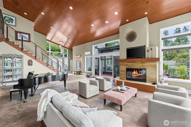 182 Island Blvd, Fox Island, WA 98333 - living room with wooden ceiling, a high ceiling, stairs, recessed lighting, and a glass covered fireplace