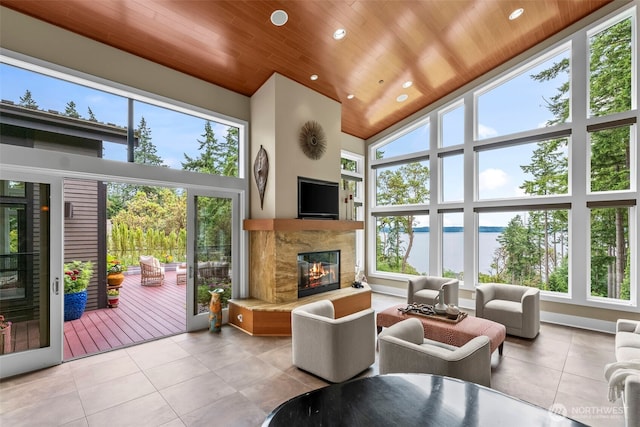 182 Island Blvd, Fox Island, WA 98333 - tiled living area with a glass covered fireplace, wood ceiling, healthy amount of natural light, high vaulted ceiling, and recessed lighting