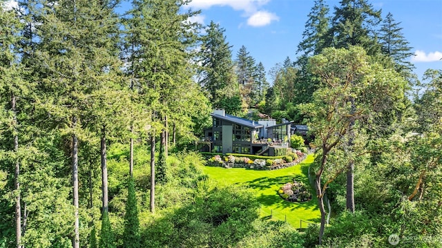 182 Island Blvd, Fox Island, WA 98333 - view of green lawn featuring a forest view and a wooden deck
