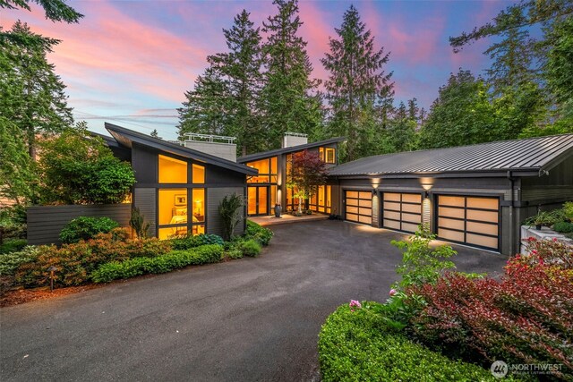 182 Island Blvd, Fox Island, WA 98333 - view of front of home featuring a standing seam roof, a garage, a metal roof, and a chimney