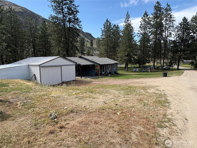 47 Pinecrest Rd, Tonasket, WA 98855 - view of green lawn featuring a pole building, a mountain view, and an outbuilding