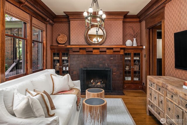 3804 S Mcclellan St, Seattle, WA 98144 - living room featuring ornamental molding, a chandelier, dark wood finished floors, wallpapered walls, and a tile fireplace