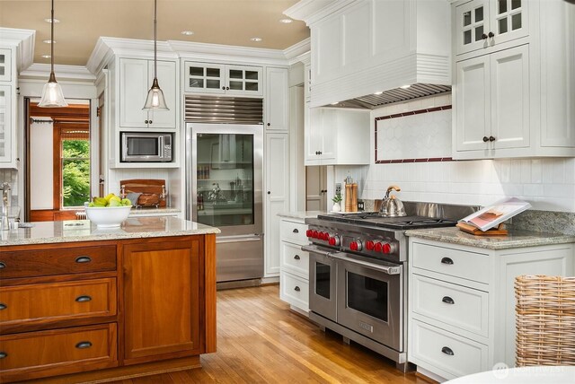 3804 S Mcclellan St, Seattle, WA 98144 - kitchen featuring built in appliances, premium range hood, brown cabinetry, white cabinetry, and crown molding