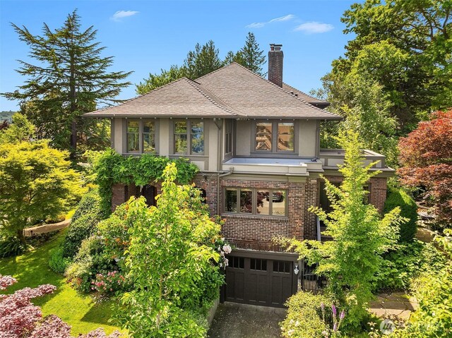 3804 S Mcclellan St, Seattle, WA 98144 - tudor home featuring stucco siding, a chimney, an attached garage, brick siding, and roof with shingles