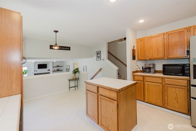 7315 E Collins Rd, Port Orchard, WA 98366 - kitchen with black microwave, light countertops, recessed lighting, a kitchen island, and hanging light fixtures