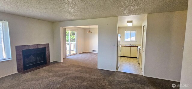 250 Charwila Ln, Enumclaw, WA 98022 - unfurnished living room featuring baseboard heating, carpet, a tile fireplace, and a textured ceiling