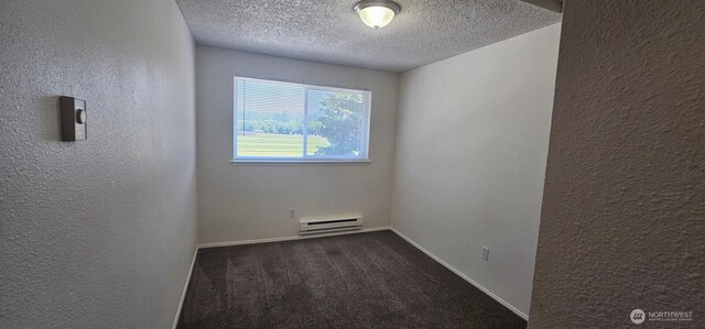 250 Charwila Ln, Enumclaw, WA 98022 - unfurnished room with a baseboard radiator, dark colored carpet, a textured ceiling, and a textured wall