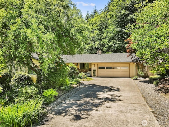 3929 Westpark Ct NW, Olympia, WA 98502 - view of front of home with concrete driveway, a garage, and a chimney