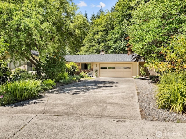 3929 Westpark Ct NW, Olympia, WA 98502 - view of front of house featuring concrete driveway, a garage, and a chimney