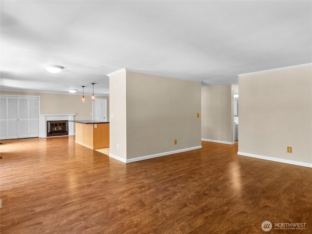 3929 Westpark Ct NW, Olympia, WA 98502 - unfurnished living room with wood finished floors, a glass covered fireplace, and ornamental molding