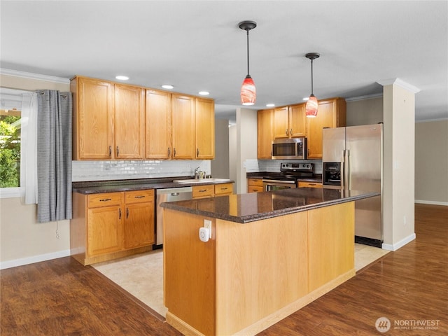 3929 Westpark Ct NW, Olympia, WA 98502 - kitchen featuring appliances with stainless steel finishes, crown molding, tasteful backsplash, light wood-style flooring, and a kitchen island