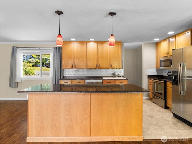 3929 Westpark Ct NW, Olympia, WA 98502 - kitchen featuring appliances with stainless steel finishes, backsplash, dark stone counters, a kitchen island, and recessed lighting