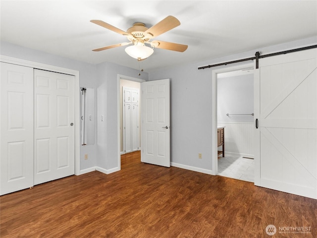 3929 Westpark Ct NW, Olympia, WA 98502 - unfurnished bedroom with wood finished floors, a closet, ceiling fan, and a barn door